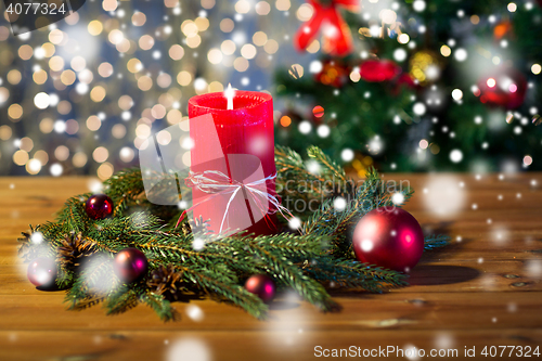 Image of fir branch wreath with candle on wooden table