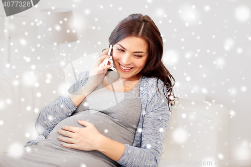Image of happy pregnant woman calling on smartphone at home