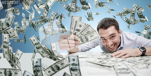 Image of happy businessman with heap of money