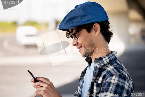 Image of hipster man texting message on smartphone