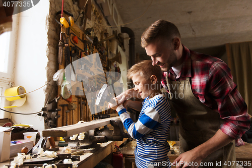 Image of father and son with hammer working at workshop