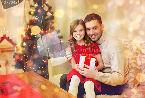 Image of smiling father and daughter holding gift box