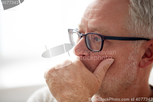 Image of close up of senior man in glasses thinking