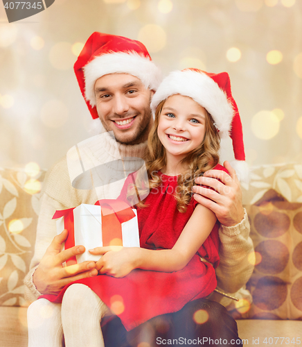 Image of smiling father and daughter holding gift box