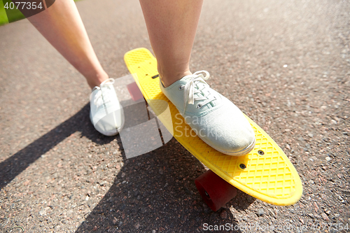 Image of close up of female feet riding short skateboard