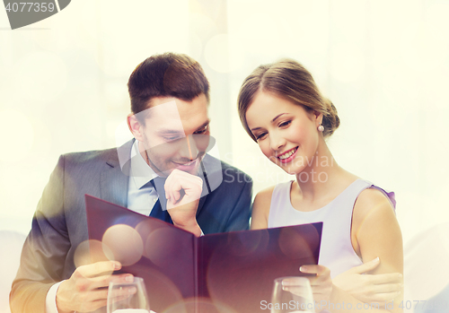 Image of smiling couple with menu at restaurant