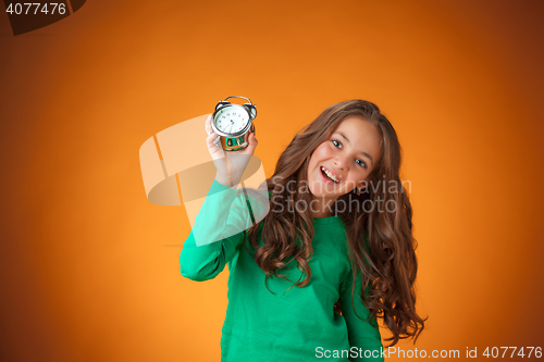 Image of The cute cheerful little girl on orange background