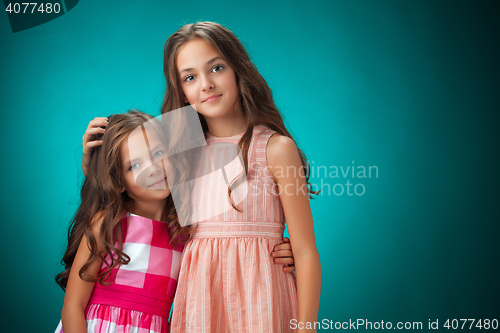 Image of The two cheerful little girls on orange background