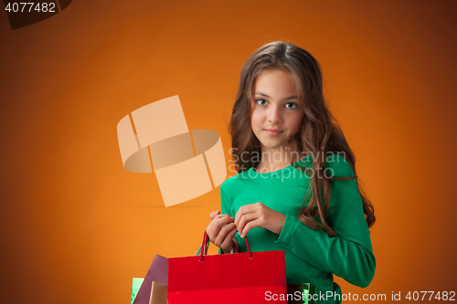 Image of The cute cheerful little girl with shopping bags