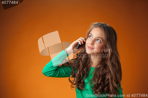 Image of The cute cheerful little girl on orange background