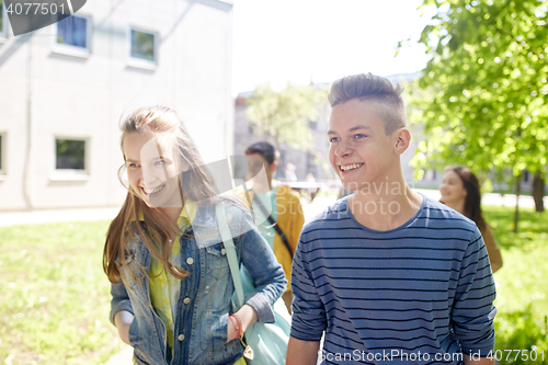 Image of group of happy teenage students walking outdoors