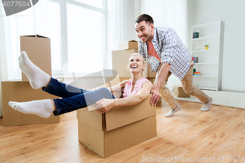 Image of couple with cardboard boxes having fun at new home