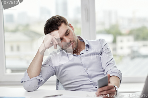 Image of  businessman with smartphone  at office 