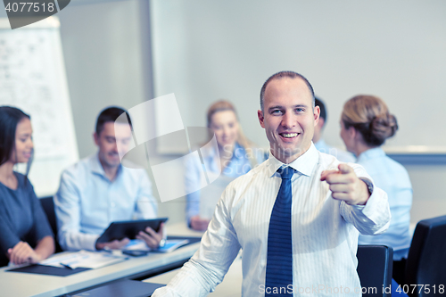 Image of group of smiling businesspeople meeting in office