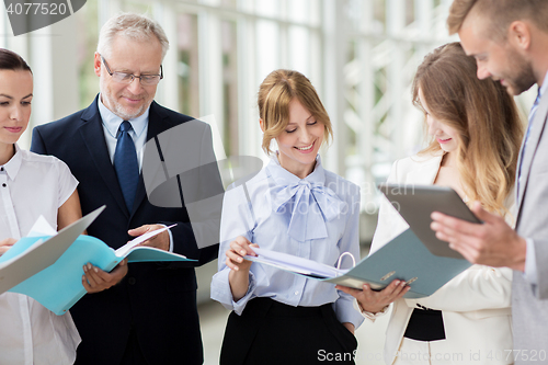 Image of business team with tablet pc and folders at office