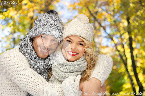 Image of happy couple in warm clothes over autumn