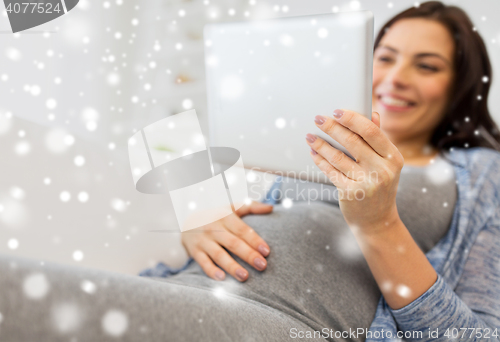 Image of close up of pregnant woman with tablet pc at home