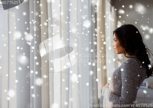 Image of close up of happy pregnant woman looking to window