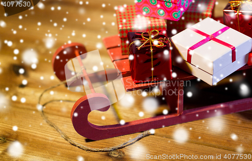 Image of close up of christmas gift boxes on wooden sleigh