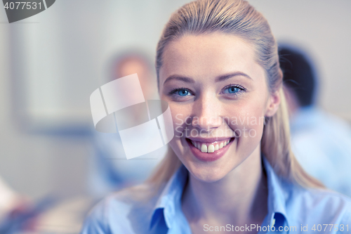 Image of group of smiling businesspeople meeting in office
