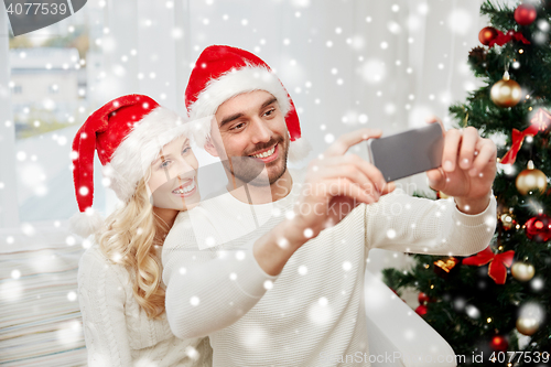 Image of couple taking selfie with smartphone at christmas