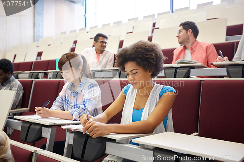 Image of group of students with notebooks at lecture hall