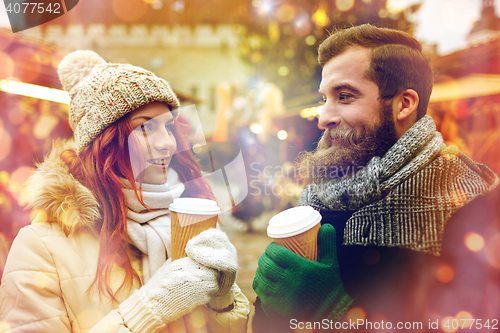 Image of happy couple drinking coffee on old town street