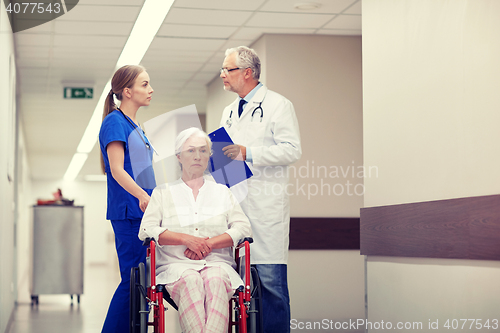 Image of medics and senior woman in wheelchair at hospital
