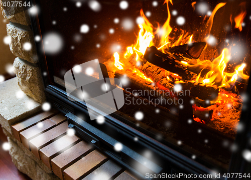 Image of close up of burning fireplace with snow