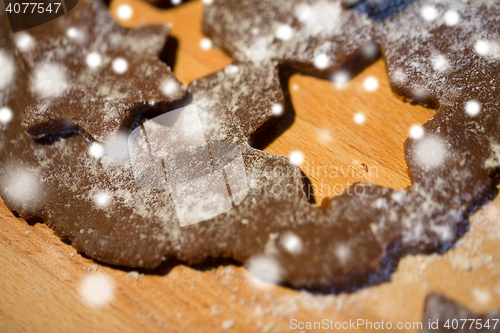 Image of close up of ginger dough, molds and flour on board