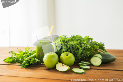 Image of close up of jug with green juice and vegetables