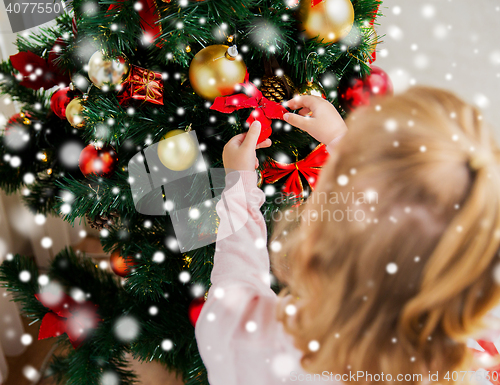 Image of close up of child decorating christmas tree