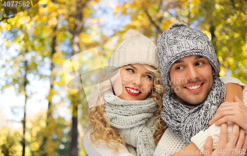 Image of happy couple in warm clothes over autumn