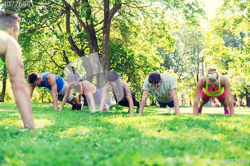 Image of group of friends or sportsmen exercising outdoors