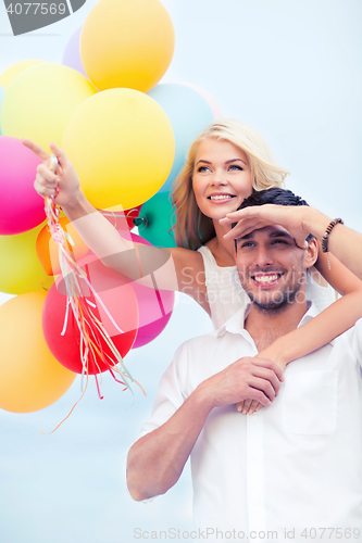 Image of couple with colorful balloons at seaside