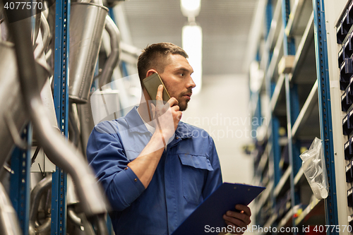 Image of auto mechanic with clipboard at car workshop