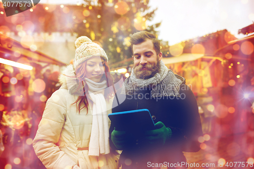 Image of happy couple walking with tablet pc in old town