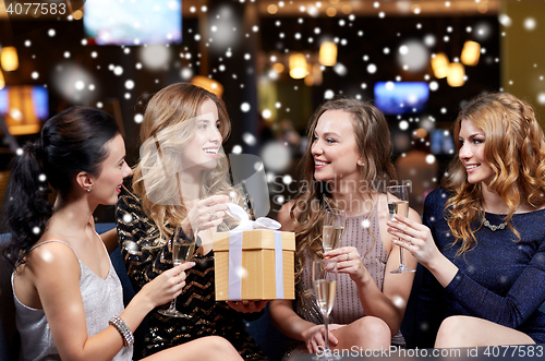 Image of happy women with champagne and gift at night club