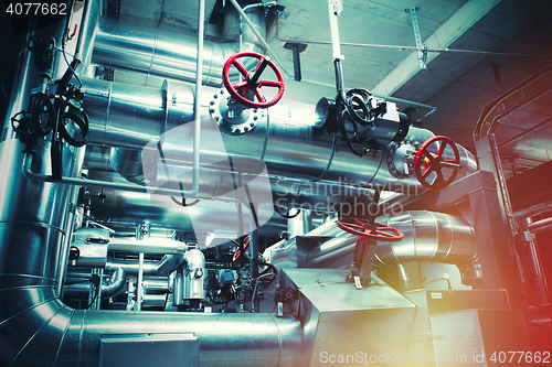 Image of different size and shaped pipes and valves at a power plant 