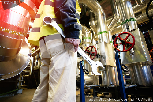 Image of industrial worker with spanner at factory workshop