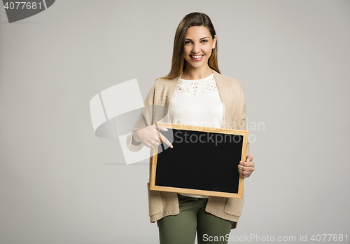 Image of Woman showing something on a chalkboard