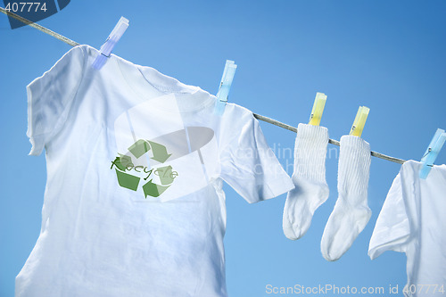 Image of T-shirt with recycle logo drying on clothesline on a  summer day