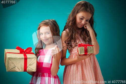 Image of The two cute cheerful little girls on blue background