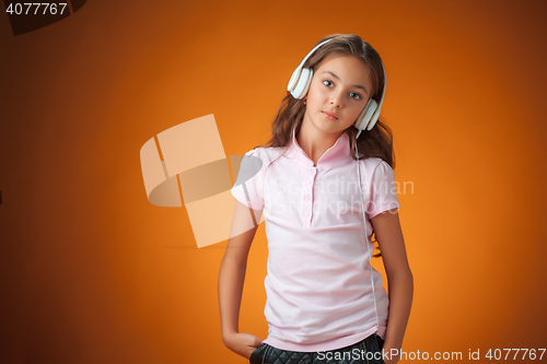 Image of The cute cheerful little girl on orange background