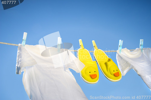 Image of White t-shirts and slippers on the clothesline