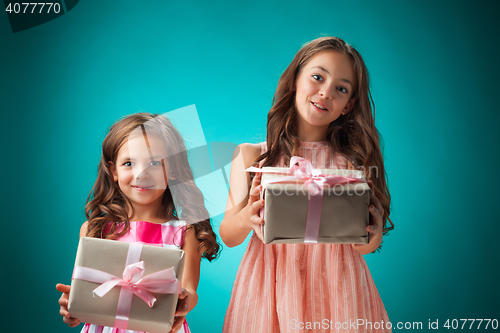 Image of The two cute cheerful little girls on blue background