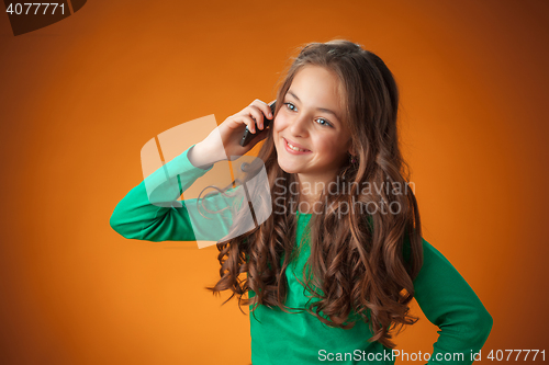 Image of The cute cheerful little girl on orange background