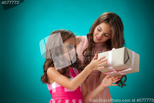 Image of The two cute cheerful little girls on blue background
