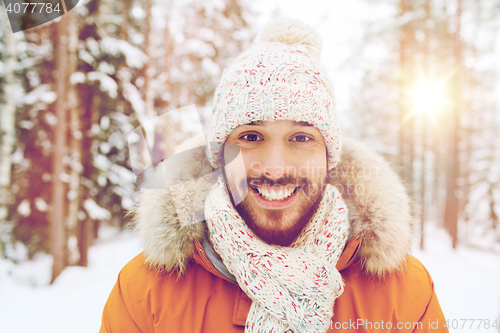 Image of smiling young man in snowy winter forest