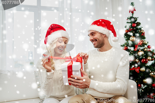 Image of happy couple at home with christmas gift box